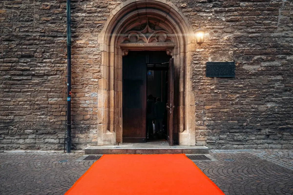 Red carpet leading to a stone archway entrance